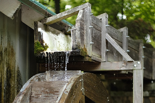 Still of water drops falling onto a wooden water wheel